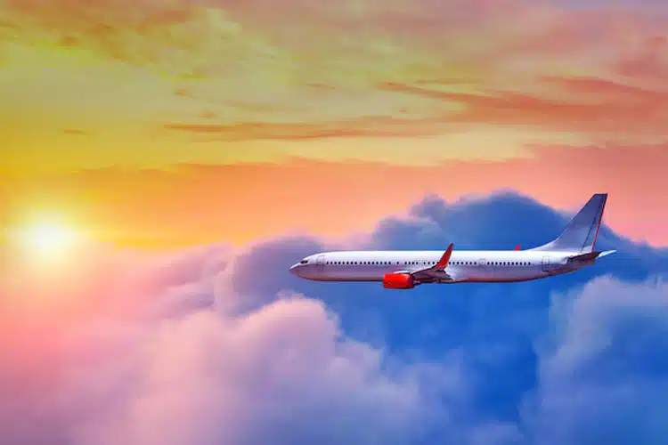 Airplane in the clouds with the sunset in the background