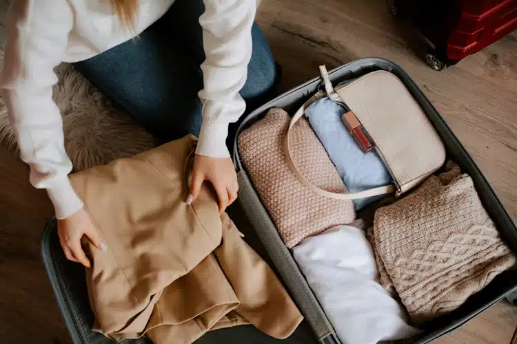 a woman busy packing her suitcase
